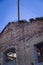 An abandoned boiler room with a dilapidated facade and a black metal pipe. Architecture of old brick houses.