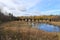 Abandoned bridge posts in the distance, and fall colors are reflected in a river in Hayward, Wisconsin