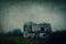 An abandoned, broken caravan in the countryside on a moody winters day. With a grunge, grainy edit