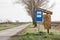 Abandoned bus stop Yugoslav design, in front of a neglected countryside landscape and a damaged road in Serbia, in a rural area