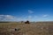 Abandoned camp with fuel barrels and buildings on a bare arctic summer landscape