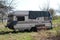 An abandoned caravan stands in a meadow and decays