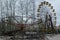 Abandoned carousel and abandoned ferris at an amusement park in the center of the city of Pripyat, the Chernobyl disaster,