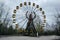 Abandoned carousel and abandoned ferris at an amusement park in the center of the city of Pripyat, the Chernobyl disaster,