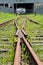 Abandoned converging railway tracks against a wall