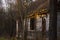 Abandoned and crumbling wooden log house among forest trees.