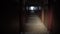 Abandoned destroyed long corridor tunnel illuminated by a lantern at night, motion tracking, POV video.