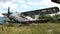 Abandoned and destroyed planes standing in thick grass of overgrown field