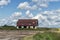 Abandoned dilapidated house with broken windows by the field