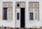 Abandoned Facade White Building with ruined Wooden Door and windows