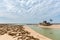 An Abandoned Fishing Boat on a beach with dry algae. At Weizhou Island, Guangxi, China.