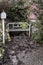 Abandoned garden, bench with a watering can, retro garden decorations. Vintage background