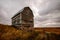 Abandoned granary in the green field.