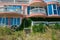 Abandoned hotel on the beach, covered in green grass and climbing ivy plant, nature take over concept, building facade