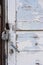 Abandoned house door texture background. Locked wooden entrance with old fashion metal padlock. Blue, white peeled off paint