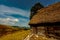 Abandoned house with thatched roof and we find green grass and the sky is clear as in a beautiful summer day