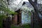 Abandoned hunting lodge in autumn forest. Dilapidated old wooden hut ruins in spring woods, sun light day