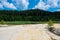 Abandoned kaolin quarry near pine forest with dirty polluted lake