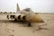 abandoned military fighter jet covered in sand