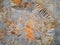 Abandoned mine tailings with helipad and colorful rusty spots over grey rough surface, view from above