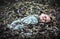 Abandoned old broken baby doll rots in scary forest