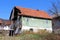 Abandoned old family house with broken roof tiles and cracked front wooden porch disconnected from power grid with hanging