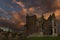 Abandoned old mansion house in ruins. Dramatic sunset with rain clouds building