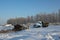 Abandoned old truck near the barn with hay in winter agricultural machinery