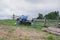 Abandoned old water tank trailer stands on the grass near a wooden fence