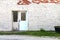 Abandoned painted white brick store doorway with exposed red brick