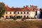 Abandoned part of old city with attached buildings with broken destroyed windows and roof tiles surrounded with stone wall and