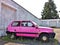 Abandoned pink Fiat Panda parked next to the white wall
