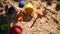 Abandoned plastic children's toys in the sand. Moving shadows of plants on the sand