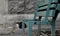 Abandoned poor cat against grey concrete wall with unfocused broken bench by foreground.