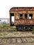 Abandoned Railroad Train Car with Peeling Patterns and Textures in Reds and Browns on Tracks
