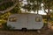 Abandoned recreational vehicle in a grove.