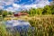 An abandoned red sinking barn sinks into a lake near Zimmerman, Minnesota on sunny day