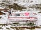 Abandoned red snowy bench with poles and freeze clothes