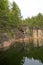 Abandoned rock quarry filled with water and bare walls.