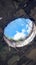 Abandoned rooftop damaged ceiling reveals cloudy sky through hole