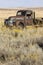 Abandoned rusted 1940s era Chevrolet farm truck in field, Easter