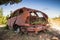 Abandoned rusted car body with growing grass