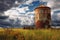 abandoned, rusted silo against cloudy sky