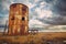 abandoned, rusted silo against cloudy sky