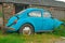 Abandoned Rusting Volkswagon Beetle by Farm Building