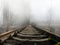 Abandoned rusty rail track in the fog. railroad tracks in the forest. Vintage railway to horizon