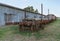 abandoned and rusty train carriages with some loaded wooden poles.