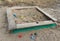 Abandoned sandbox with broken toys