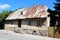 Abandoned small urban family house on broken stone and concrete foundation with damaged facade around destroyed windows