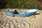 Abandoned small wooden boat -patera- on a beach near Tarifa, coast of Andalusia, Spain.